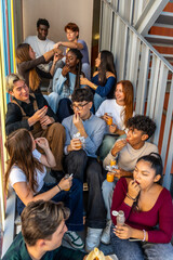 Fototapeta premium Diverse students eating snacks and drinking beverages on school stairs