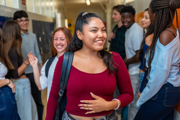 Obraz premium Diverse high school students smiling and socializing in hallway