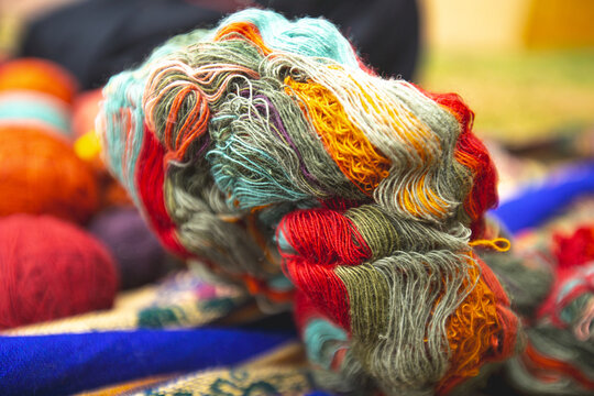 View of colorful naturally dyed wool yarn with vibrant red, orange, yellow, and blue fibers in Cusco, Cusco, Peru.
