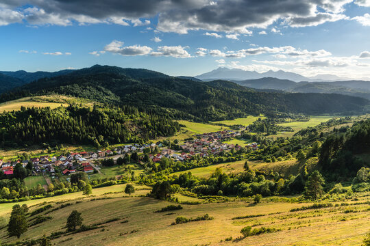 View of the village of Velky Lipnik nestled in a valley surrounded by green hills, dense forests, and distant mountains in Velky Lipnik, Presovsky kraj, Slovakia.