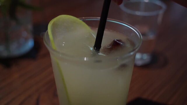 Close up. Someone stirring an iced drink before drinking.