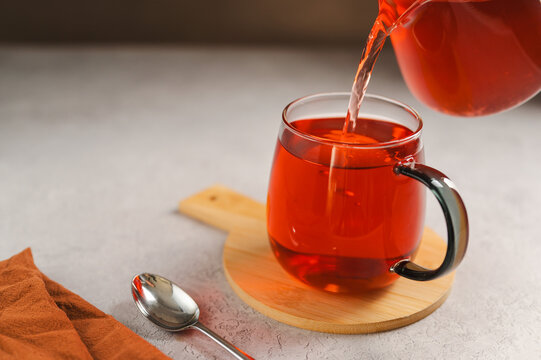 Warm tea in glass cup with lemon and lemon, cozy autumnal drink