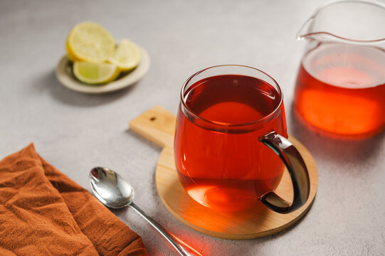 Warm tea in glass cup with lemon and lemon, cozy autumnal drink