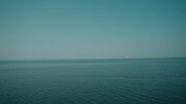 Offshore wind farm with rows of wind turbines rising from the Irish Sea, with a vessel sailing nearby, illustrating Ireland growing renewable energy infrastructure - Ireland - 31 August 2026.