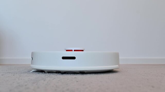 Smart vacuum cleaner cleans the floor in the apartment. A smart home, housekeeping concept