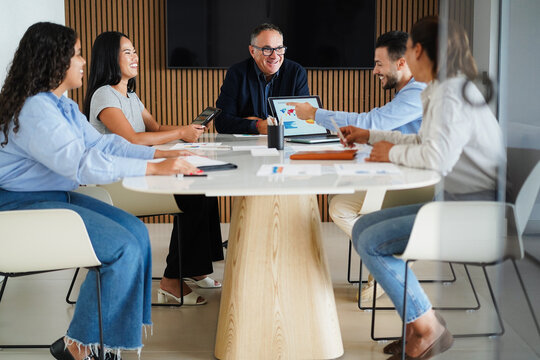 Multiracial colleagues working inside business office with glass walls - Entrepreneurs people sharing ideas at teamwork meeting - Brainstorming concept - Main focus on center man face