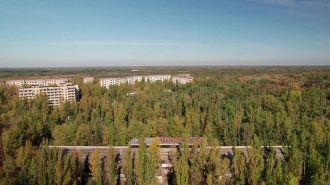 Aerial view of abandoned Soviet-era apartment blocks overgrown with trees in the exclusion zone of Chornobyl, Kyiv Oblast, Ukraine.