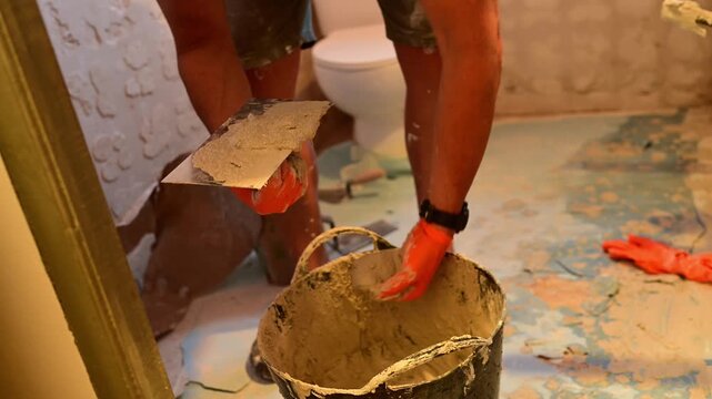 Construction worker plastering a wall with a trowel