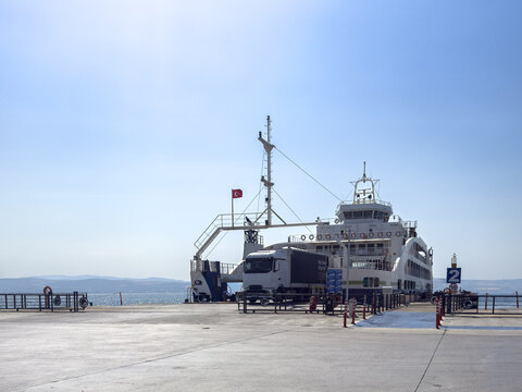 View of a ferry docked at the pier with a truck waiting to board under a clear blue sky in Canakkale, Canakkale, Turkey.