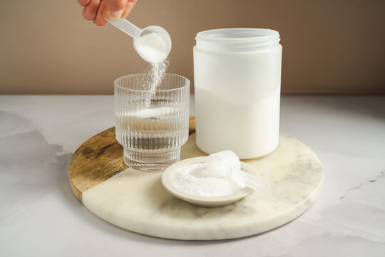 Woman adding collagen supplement to glass of water, self care product. Copy space