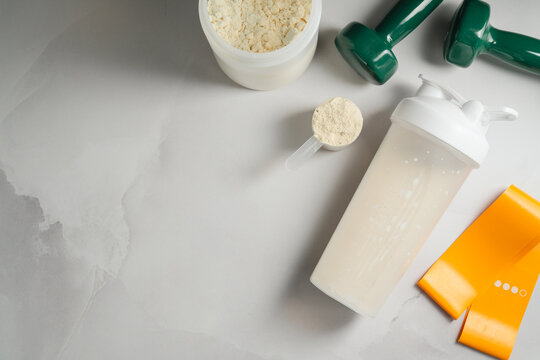 Post workout nutrition concept with protein shake and fitness gear, copy space