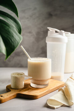 Adding vanilla protein powder to glass for muscle recovery beverage