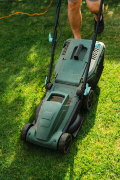 Person mowing lawn in backyard garden, home lawn care and summer yard maintenance