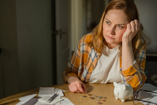 Paying bills and household budgeting concept with thoughtful woman at home, copy space