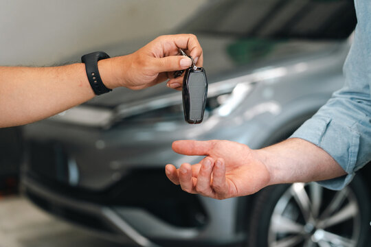 Electric vehicle battery car service Car key handover between two people beside modern vehicle, representing purchase, rental, ownership, service, and customer satisfaction during successful
