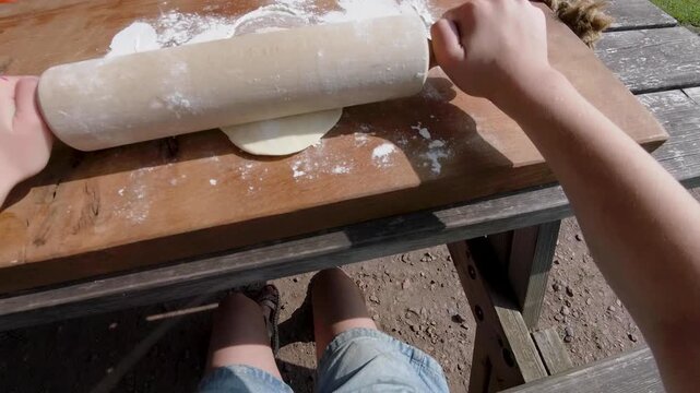 Girl POV rolling pizza dough with rolling pin