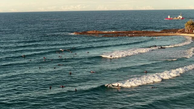 Snapper Rocks surf break at sunset with surfers in the water, aerial view, Gold Coast, Queensland Australia