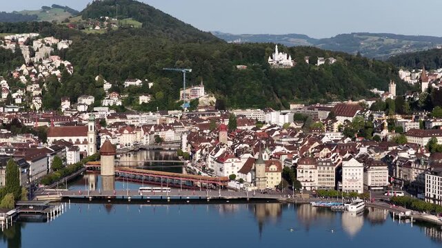 Lucerne Switzerland aerial drone view medieval city wall tower old town Chapel bridge lake hillside mountains Swiss alps travel destination.