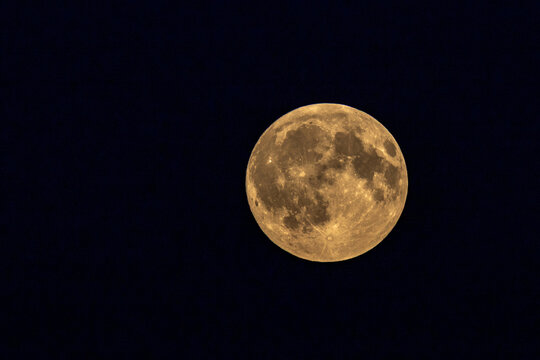View of the full moon glowing against the dark night sky in Vilnius, Vilnius County, Lithuania.