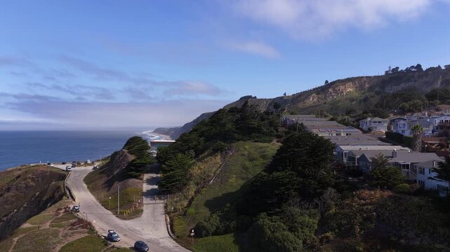 Aerial view of the Pacific Ocean coastline at Mussel Rock Park in Daly City, California, showing the scenic landscape, rugged cliffs, and coastal homes on a sunny day