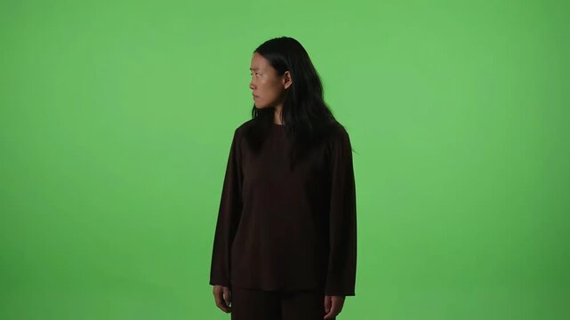 Asian woman sad expression green screen chroma key background concerned portrait looking at camera depressed emotional person