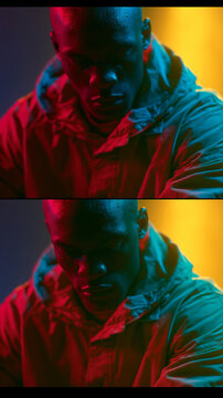 Cinematic two-panel vertical portrait of a pensive Black man in a hooded jacket under dramatic red, blue, and yellow neon lighting, creating a moody and atmospheric film still aesthetic.