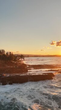 Aerial drone footage of the Snapper Rocks headland in golden evening light, Coolangatta, Queensland Australia - vertical video