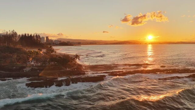 Sunset over Snapper Rocks with the Gold Coast skyline in the distance, aerial drone view, Queensland Australia