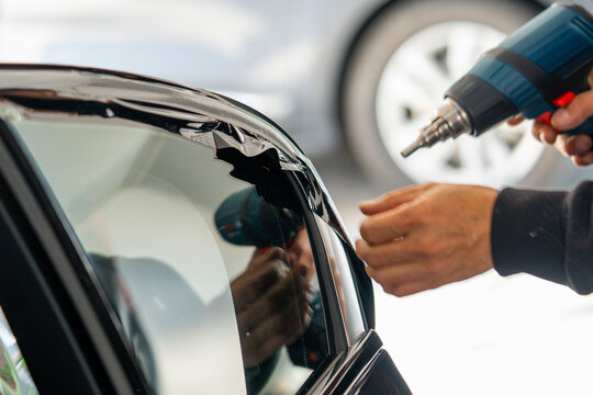 A car wrapping specialist applies a polyurethane film to the car. Detailer PPF