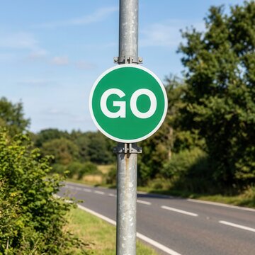 Green Go Sign On A Pole Along A Scenic Country Road