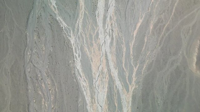 High altitude aerial drone shot flying forward over a river bed canyon, tilting up to reveal a vast majestic Mongolian steppe, flat log profile
