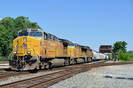 Three Union Pacific Railroad locomotives lead a freight train across a double diamond crossisng after spanning one of multiple railway bridges across the Cal-Sag Channerl in south suburban Chicago.