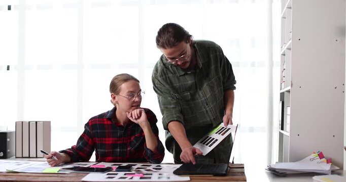 Ux ui designers collaborating on web and mobile application development, reviewing wireframes and prototypes, working on responsive design and user experience research
