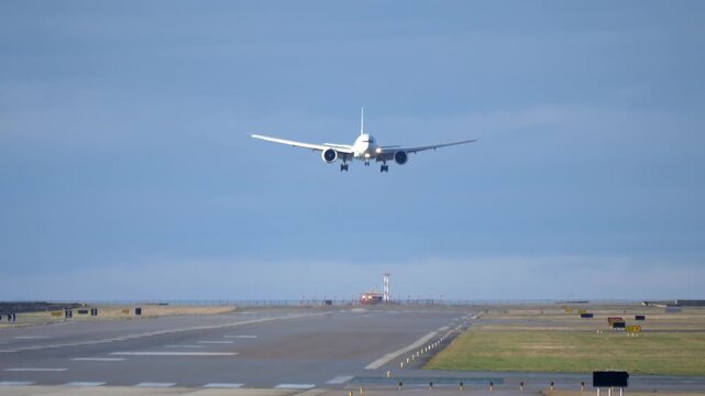 Wide Body Airliner Airplane Lands on Runway - Telephoto Frontal View