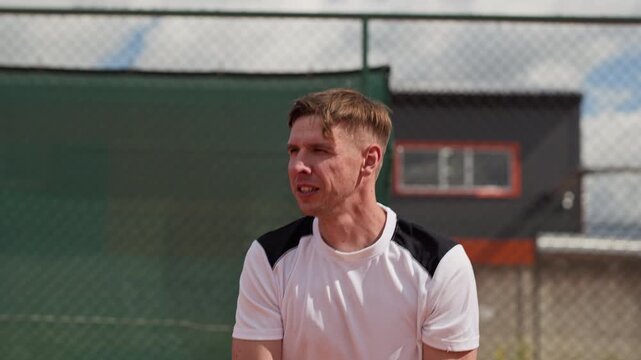 Caucasian young adult man practicing backhand swings with racket on outdoor tennis court. Footage suitable for sports marketing, fitness training promotions, athletic brand campaigns