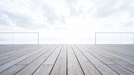 Obraz premium weathered white wooden deck terrace with glass railing overlooking cloudy sky and bright horizon during daytime at luxury resort hotel