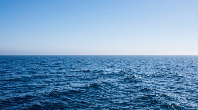 Vast minimalist seascape with deep blue waves meeting a clear gradient sky at a straight horizon, calming infinite marine atmosphere