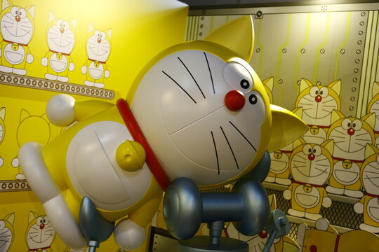 A large yellow original Doraemon statue with ears on display.