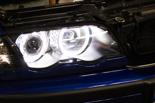 Krakow, Polska - September 06, 2026: Close-up of modern car headlight with LED technology, showcasing intricate design and bright illumination on a blue vehicle