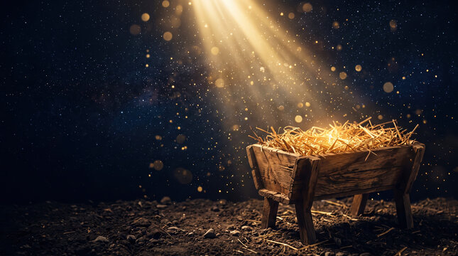 A wooden cradle rests on the ground, filled with straw. Rays of light shine down, creating a bright spot. The background is dark with a starry effect