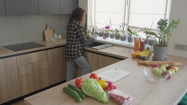Woman Unpacking Fresh Groceries In Modern Kitchen