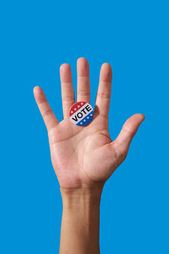 man displaying vote badge on open palm