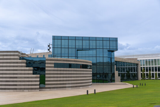 Arteixo, spain - july 26 2026: Inditex headquarters building facade in arteixo, spain. modern corporate building exterior featuring glass and striped stone cladding with green lawn