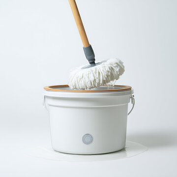 Round white spin mop head spinning and wringing out over a cleaning bucket on a white background
