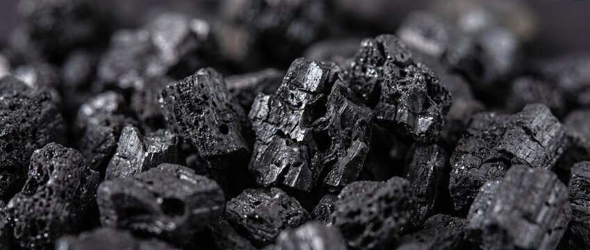 Extreme close up of activated charcoal pieces. Macro texture of black porous carbon granules