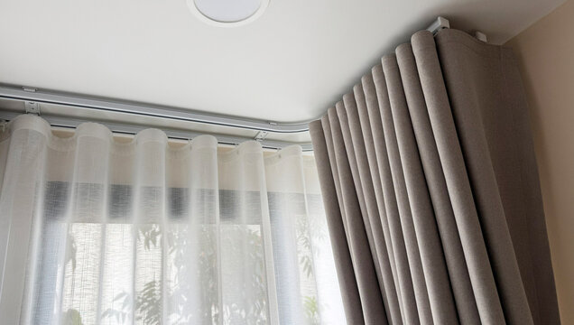 Luxury beige ripple fold curtains with white sheer on a curved track