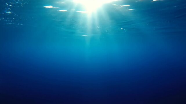 Sunlight filtered through deep blue ocean waters peaceful underwater scene
