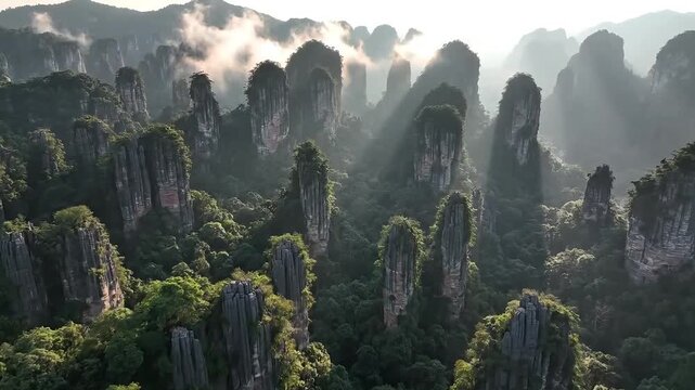 Aerial shot of sandstone karst pillars with sun rays and mist