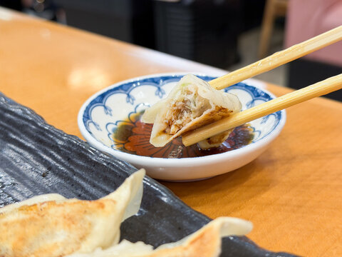 タレにつけて食べる餃子。断面のクローズアップ。