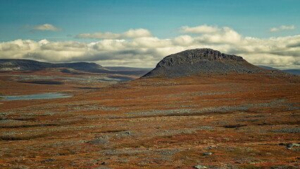 Enontekio, Finland - 28.08.2026: Rugged rocky plateau rising above vast brown arctic tundra under a cloudy sky with distant hills © Andrei